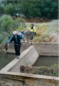 Carrying bikes across the broken concrete across Duck River